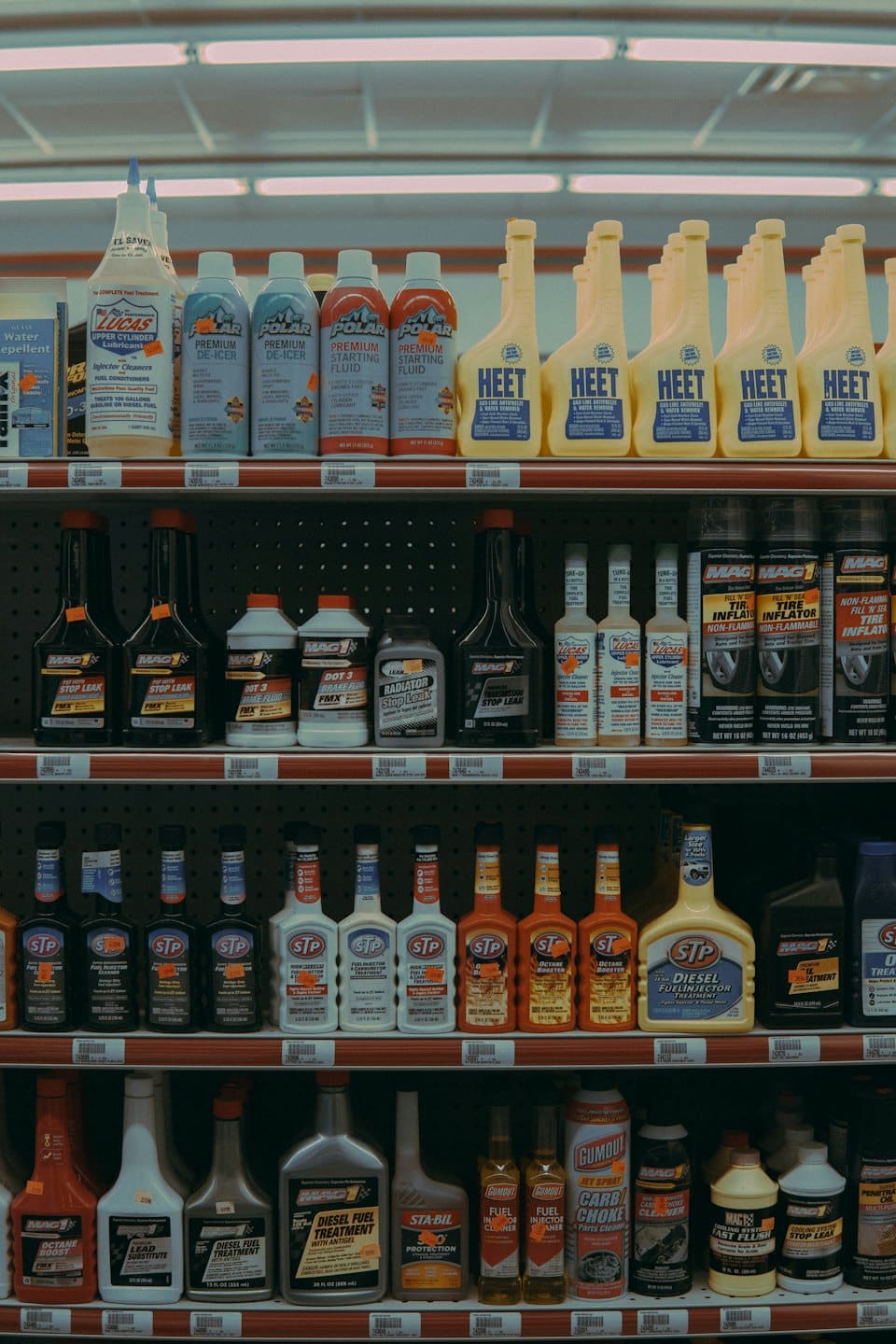 Shelves stocked with various automotive fluids and car care products.